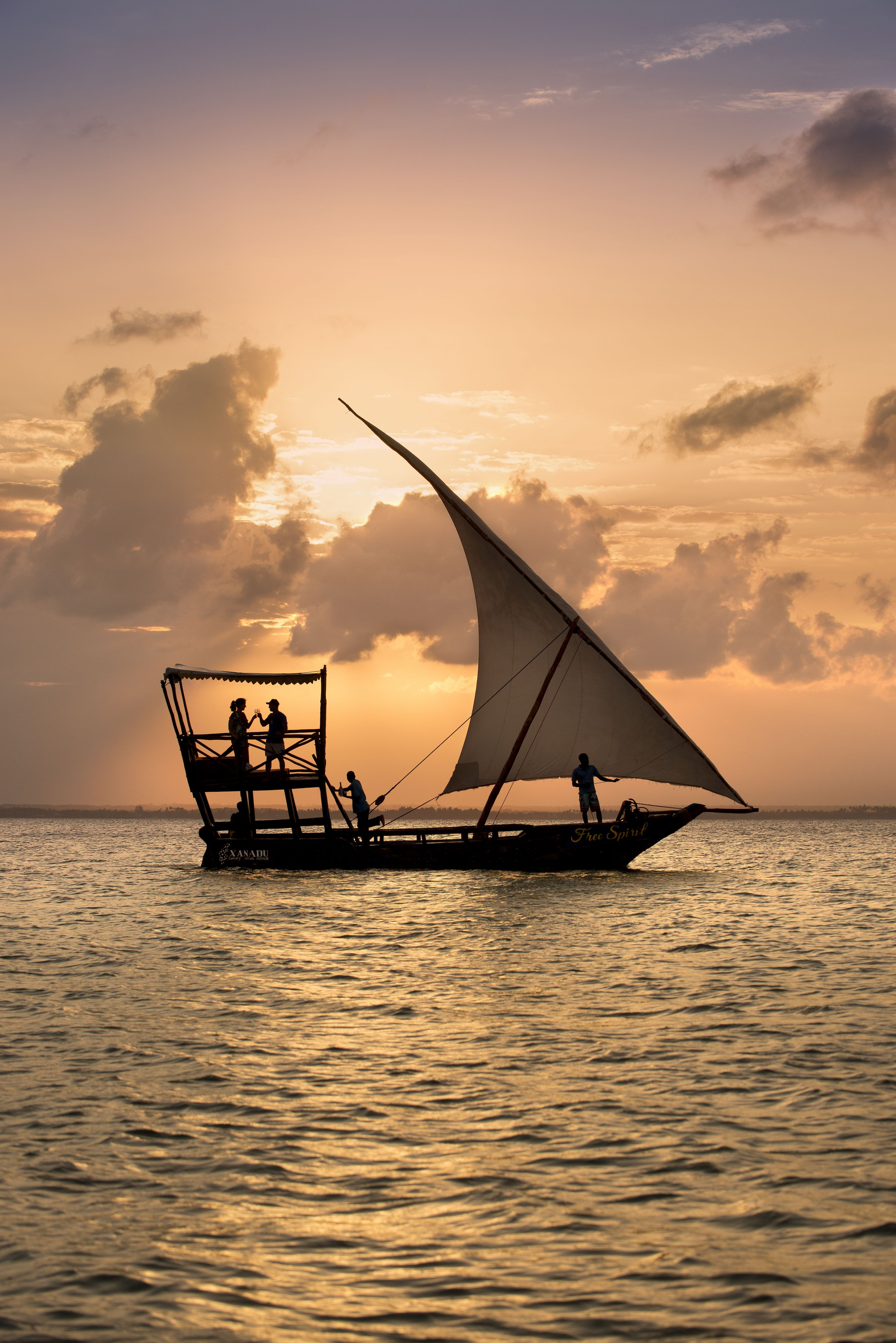 Traditional dhow sailing at sunset off Diani, Kenya