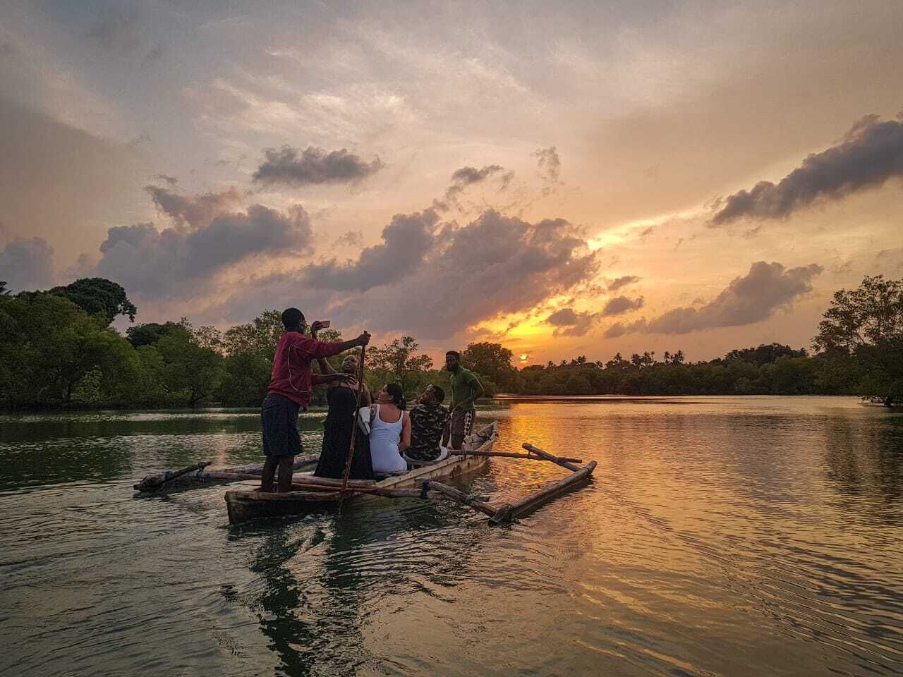Guests taking a traditional boat cruise on the Kongo River at sunset