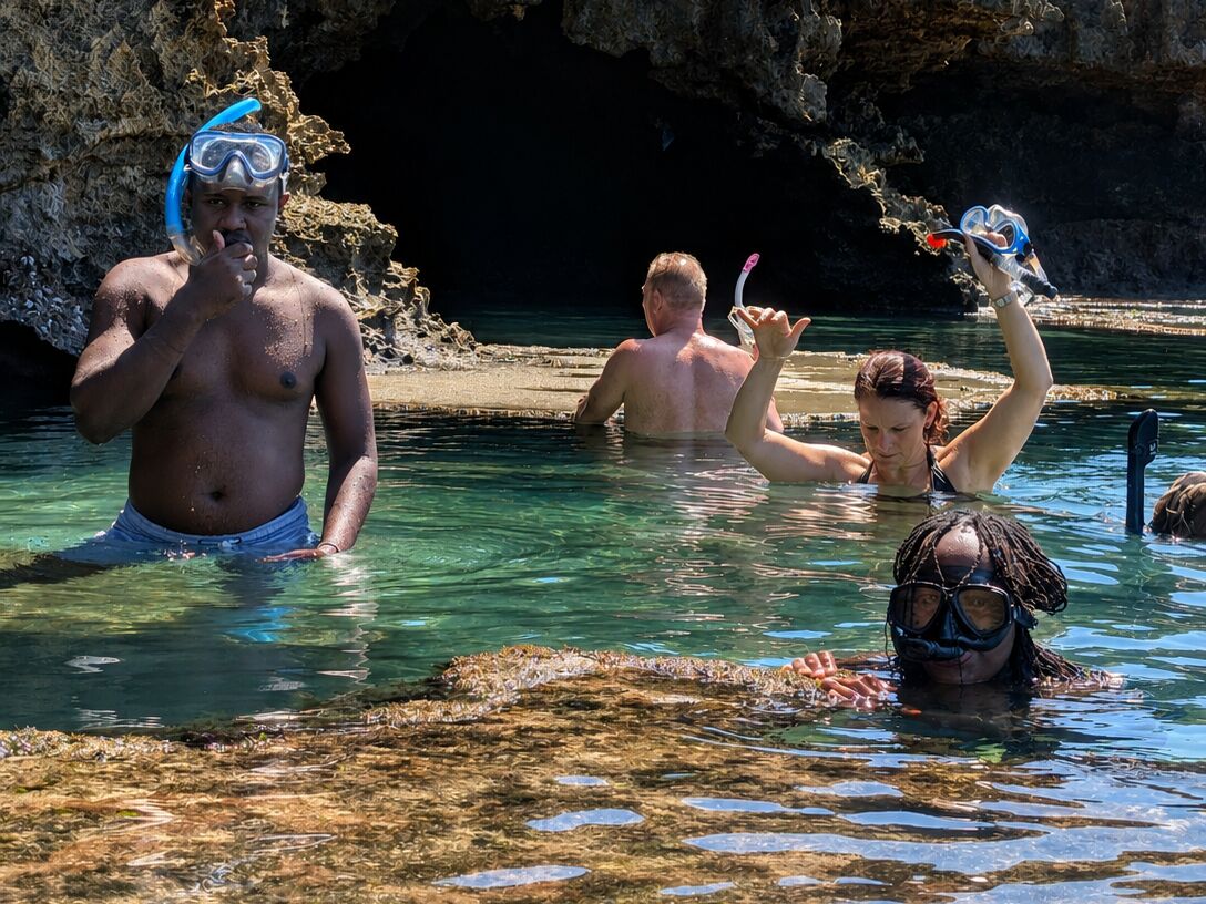 Guests snorkelling in a hidden sea cave, Diani, Kenya